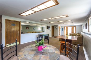 Relaxing area of the community room with tables for game night or relaxing.